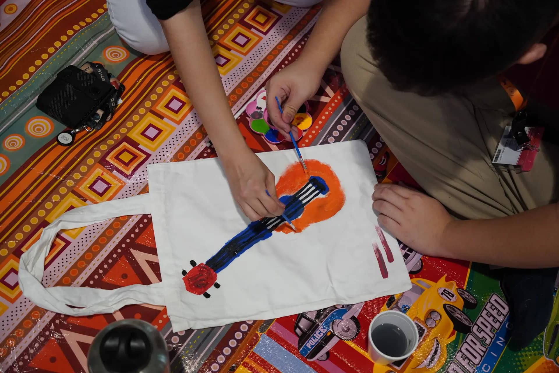 A person painting on a canvas totebag