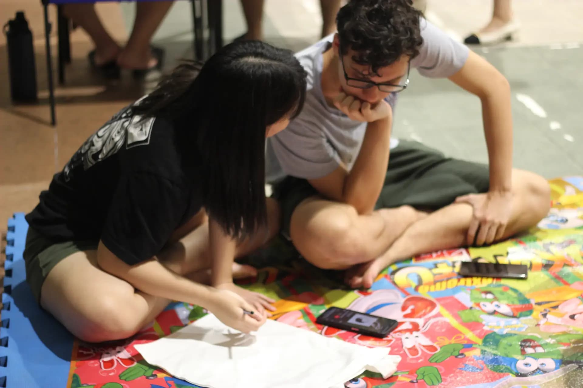 A person painting on a canvas totebag